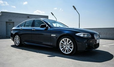 Black BMW Saloon car from side on with silver alloy wheels