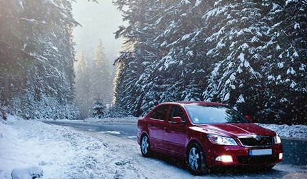 A car driving in snowy weather conditions.