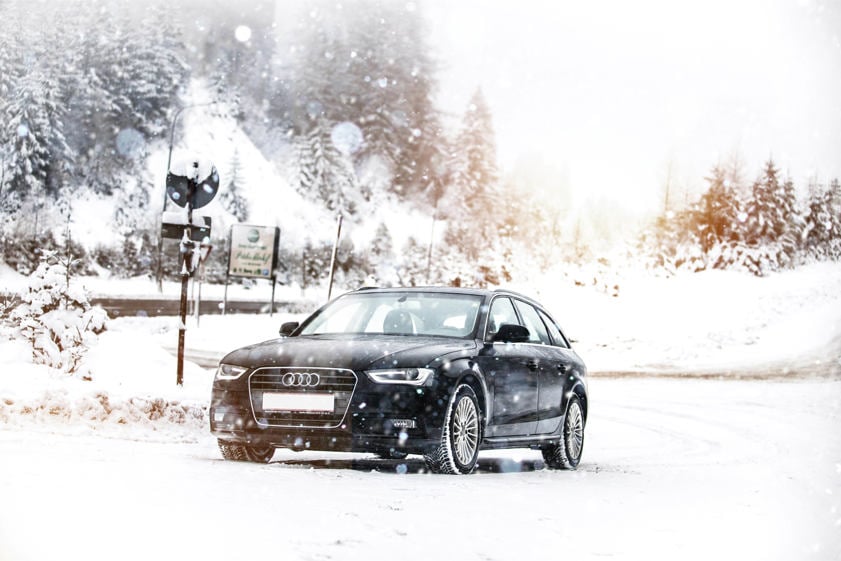 car driving through a very snowy forest