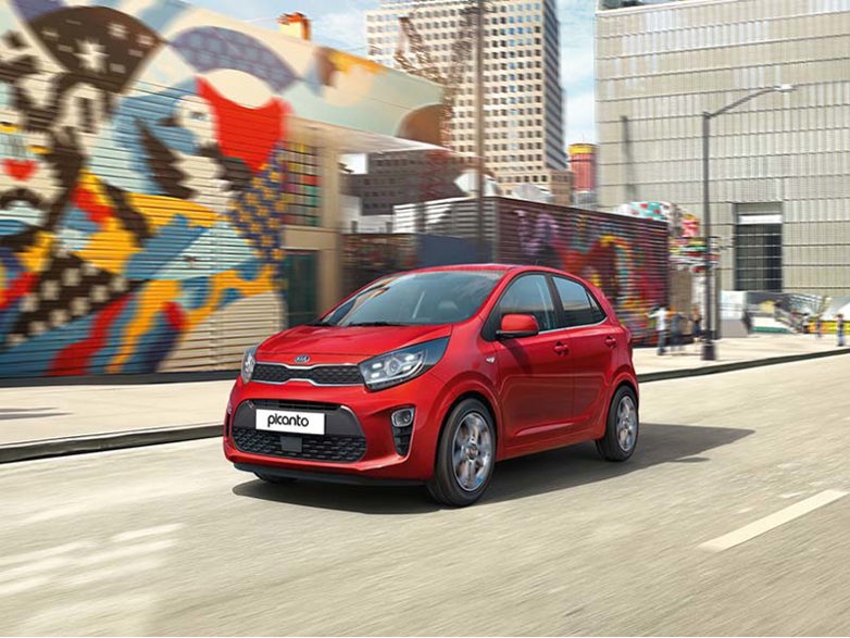 Red Kia Picanto on a vibrant city street