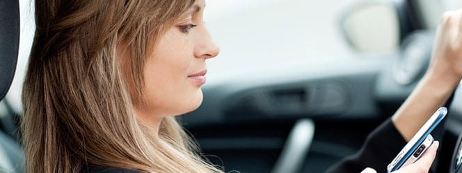 woman using phone whilst driving