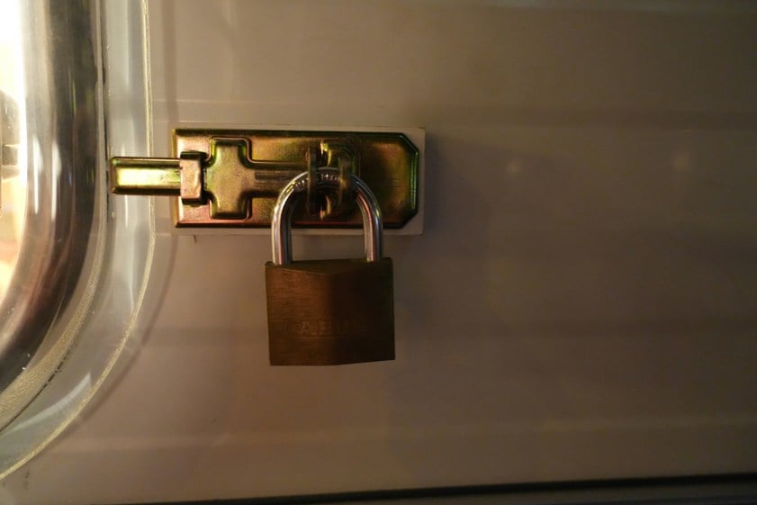 a brass padlock secures a metal latch