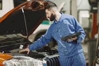 Professional mechanic examining a car in a garage