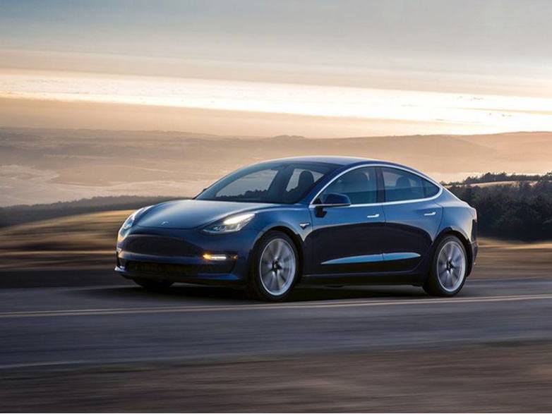 black tesla model 3 driving on the road