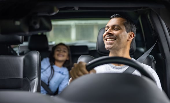Happy father driving with his daughter in the car