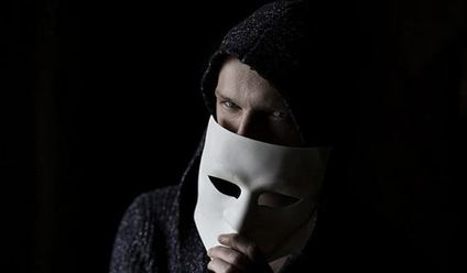 Close up of scammer hiding behind a mask.