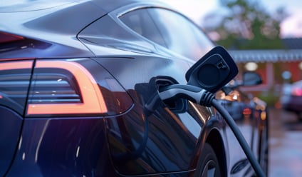 Close-up view of an electric car in blue being charged at a public charging station