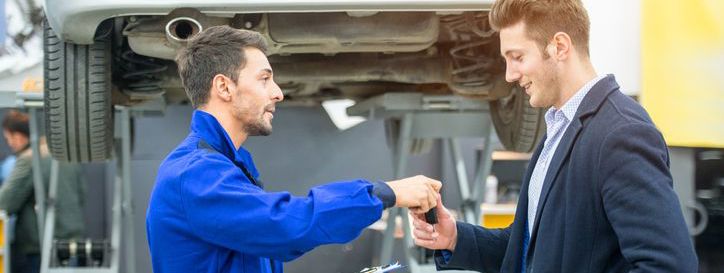 Mechanic handing car key to customer at a garage
