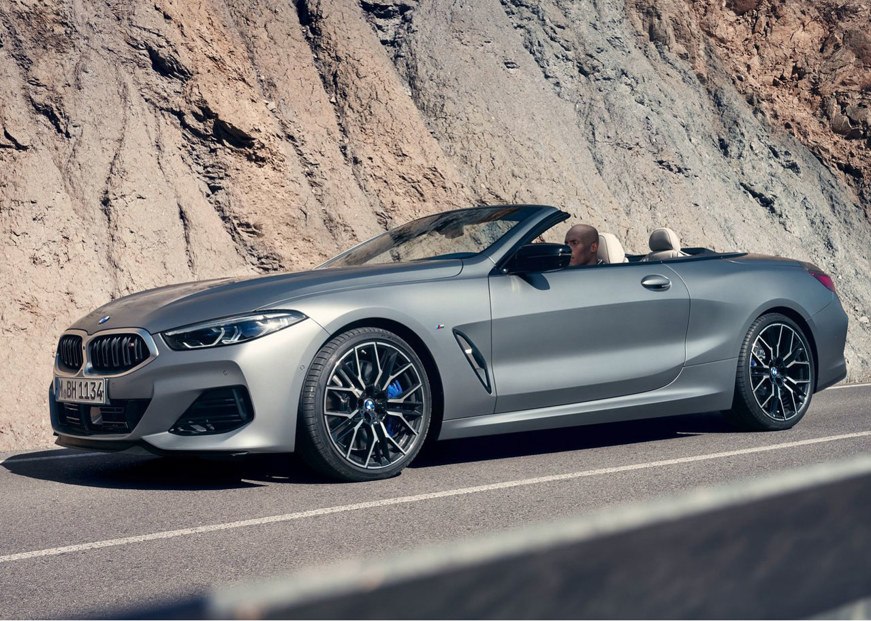 BMW 8 Series Convertible driving on the road from side on view