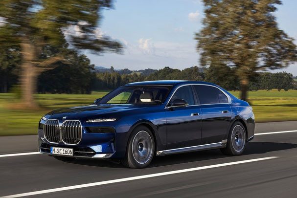 blue bmw 7 series driving on the road 