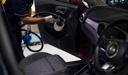 A man disinfecting a car's interior. 