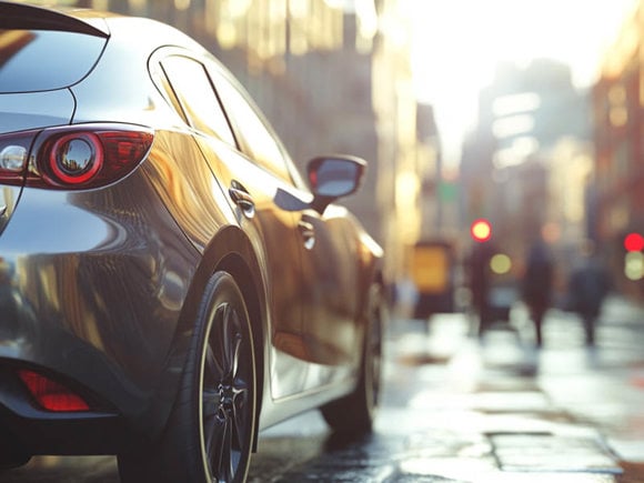 Japanese hatchback parked in a city with soft sunlight