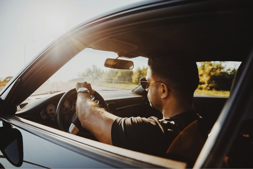 Men driving lease car in sunset