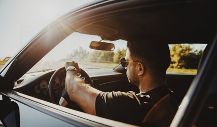 Men driving lease car in sunset