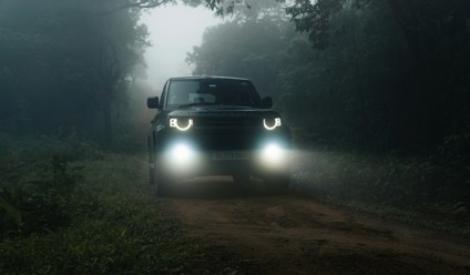 a truck driving down a dirt road in the dark