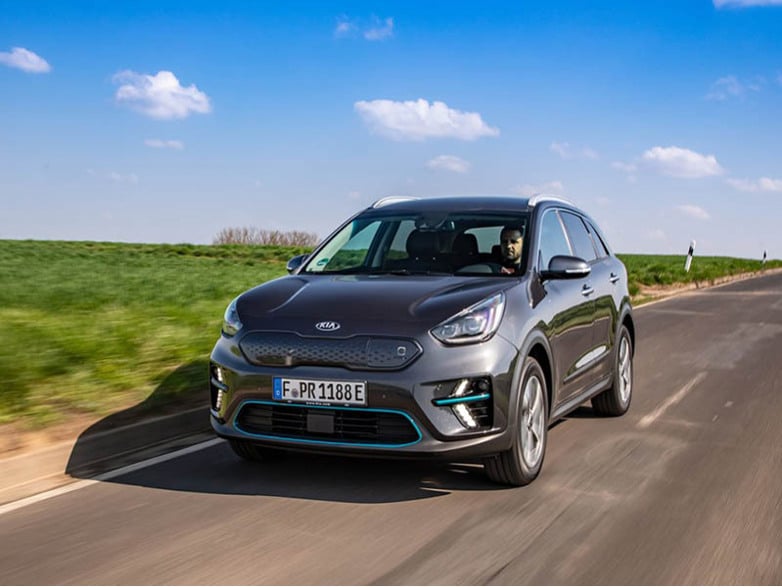 dark grey kia niro ev driving on the road