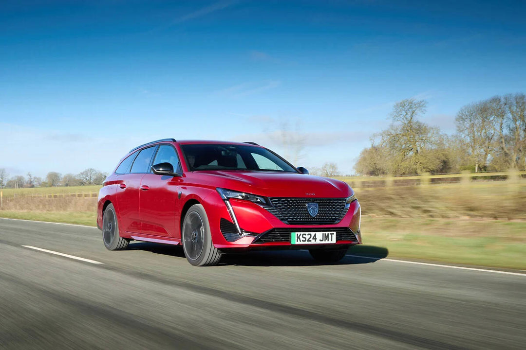 Peugeot e-308 SW lease car in red driving on the road