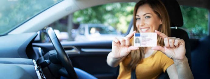 Lady holding up her driving license