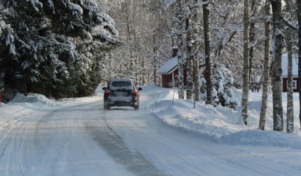 black car on road covered with snow during daytime