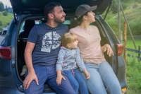 Family sitting on the back of a car