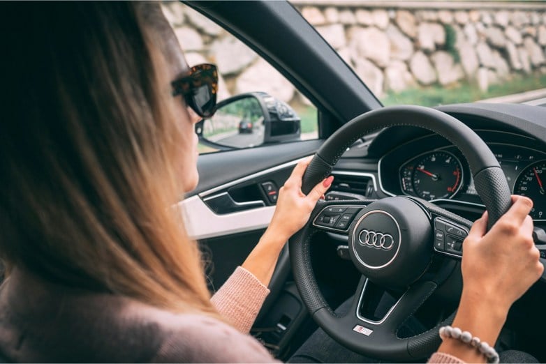 Woman driving an Audi with two hands on the steering wheel