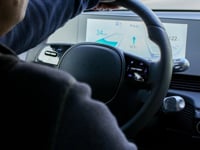a man driving an electric car on a snowy road