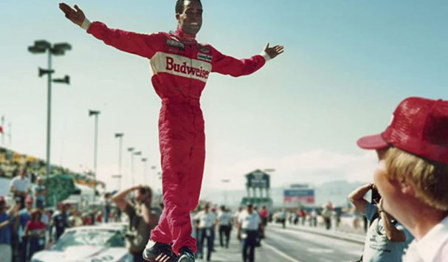 A promotional image for the documentary "Uppity: The Willy T. Ribbs Story," featuring Willy T. Ribbs in a racing suit and helmet.