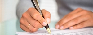 close up of man signing documents