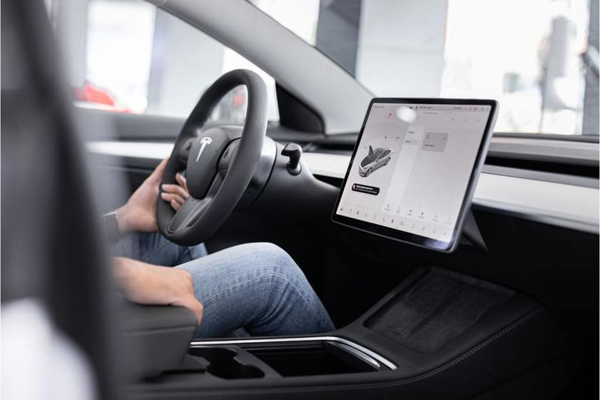 Person sitting in a Tesla with the large touchscreen visible