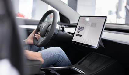 Person sitting in a Tesla with the large touchscreen visible