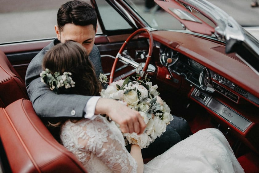 couple on wedding day sat in classic car