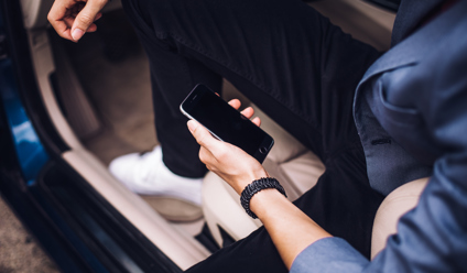 Man Holding iPhone in His Car