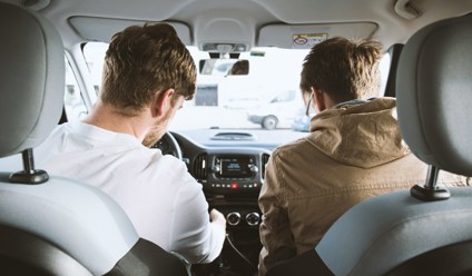 two men sitting in the front of a car