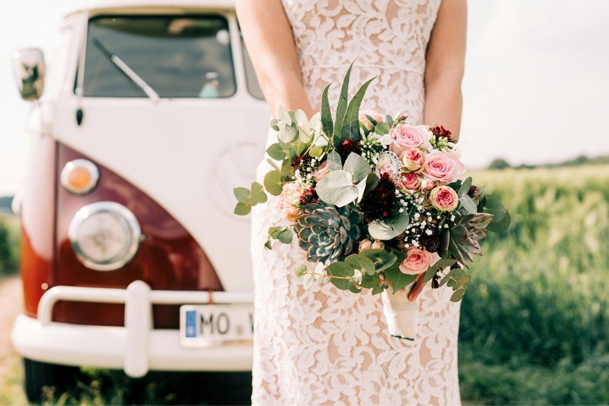 woman in white floral dress in front of vw campervan