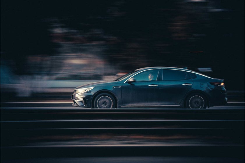 Black saloon car driving on the road