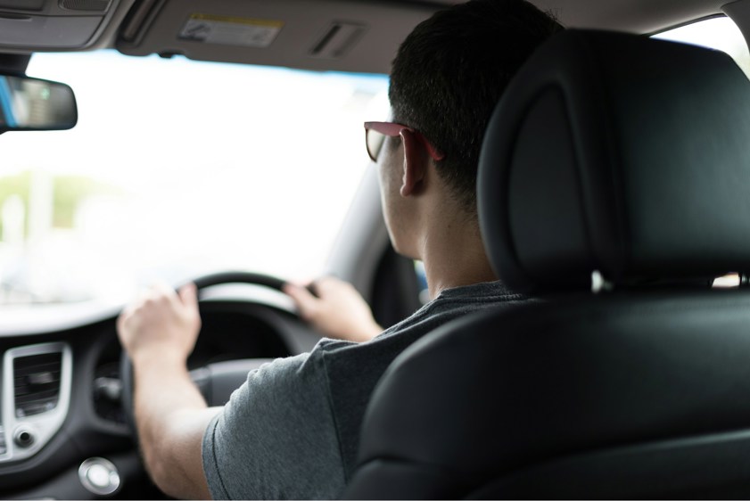 Man driving car with both hands on the steering wheel