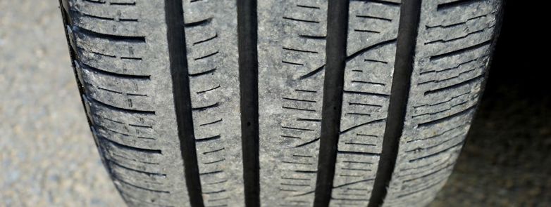 Detailed macro shot of a worn car tire tread showing wear and texture.