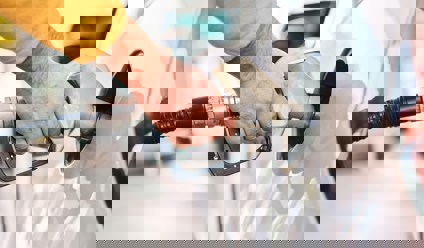 Person filling a white car with fuel