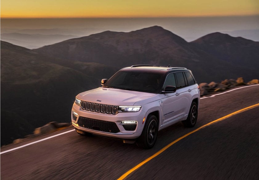 Jeep grand Cherokee in white driving on a mountain road