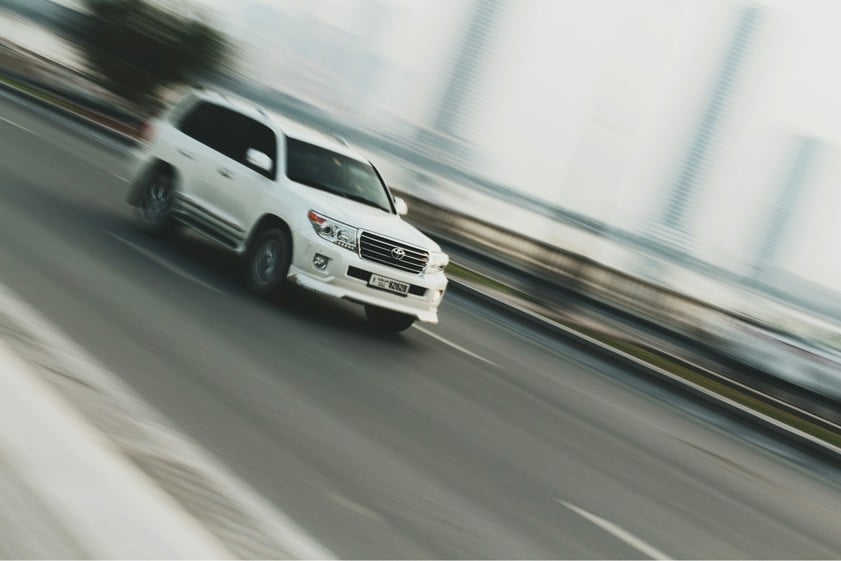 White SUV driving on a highway