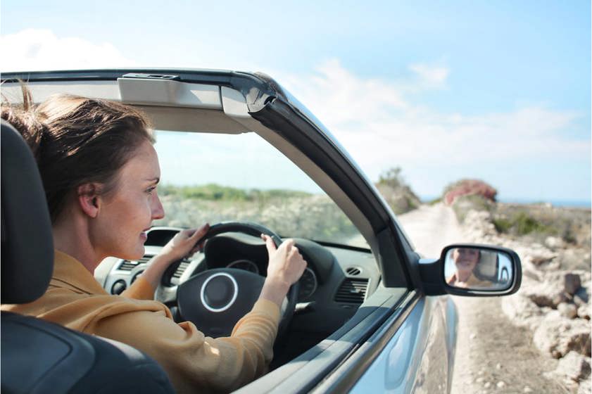 Woman driving convertible car