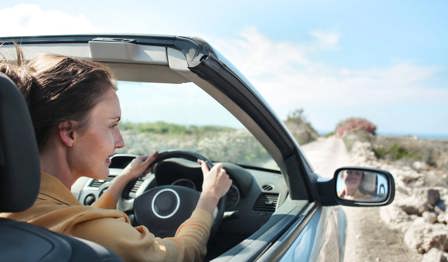 Woman driving convertible car