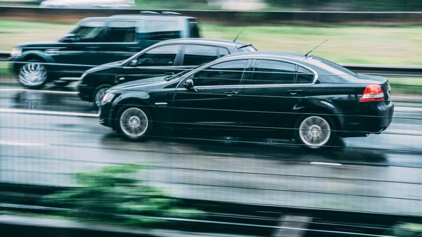 Black saloon car driving on the road