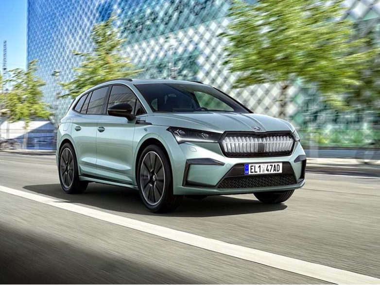 blue skoda enyaq iv driving on road