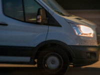 a white van driving down a street at night
