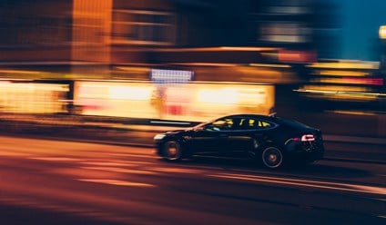 Saloon car driving at night with time span effect