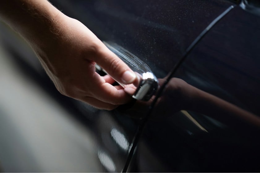 Person using car door handle