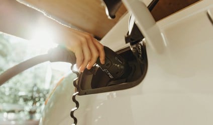 Person charging an electric car at home