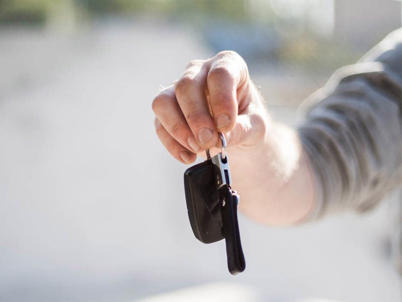 Person in a grey sweater holding their car keys