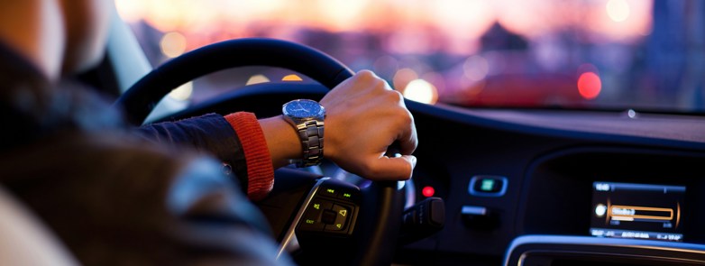man driving a car wearing wrist watch
